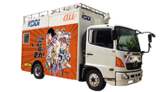 auの車載型基地局コラボ第4弾、今年の夏コミケは「弱虫ペダル」！自転車型の人力スマホ充電器も設置！
